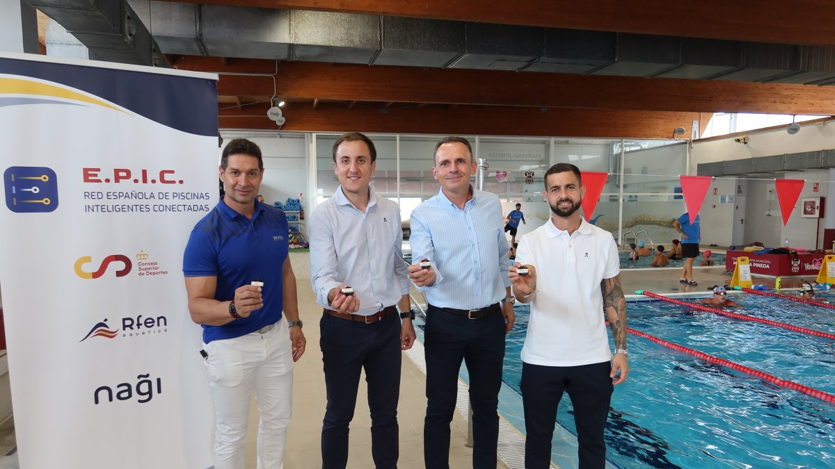 Autoridades y responsables de la empresa y la piscina posan con el chip que hace posible la medición.