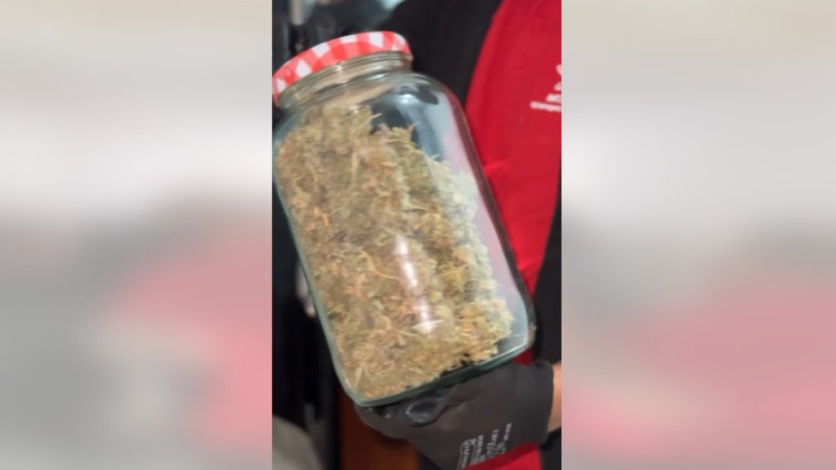 Fotograma del video donde muestran un frasco con cogollos de marihuana.