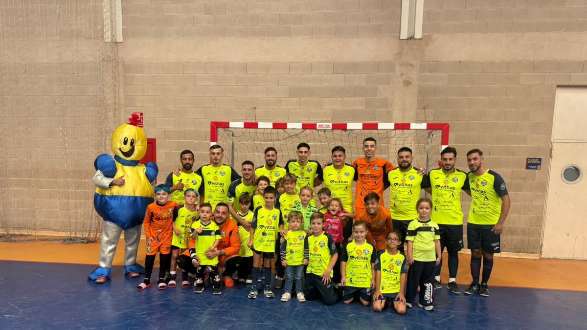 Foto de familia de los jugadores de Almería Futsal con los más pequeños y la mascota de Toy Planet.
