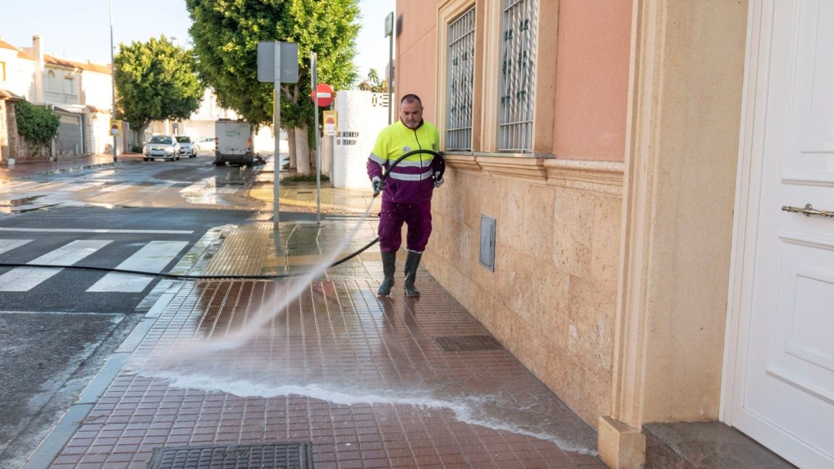 Trabajador del servicio de limpieza de la capital baldeando las calles