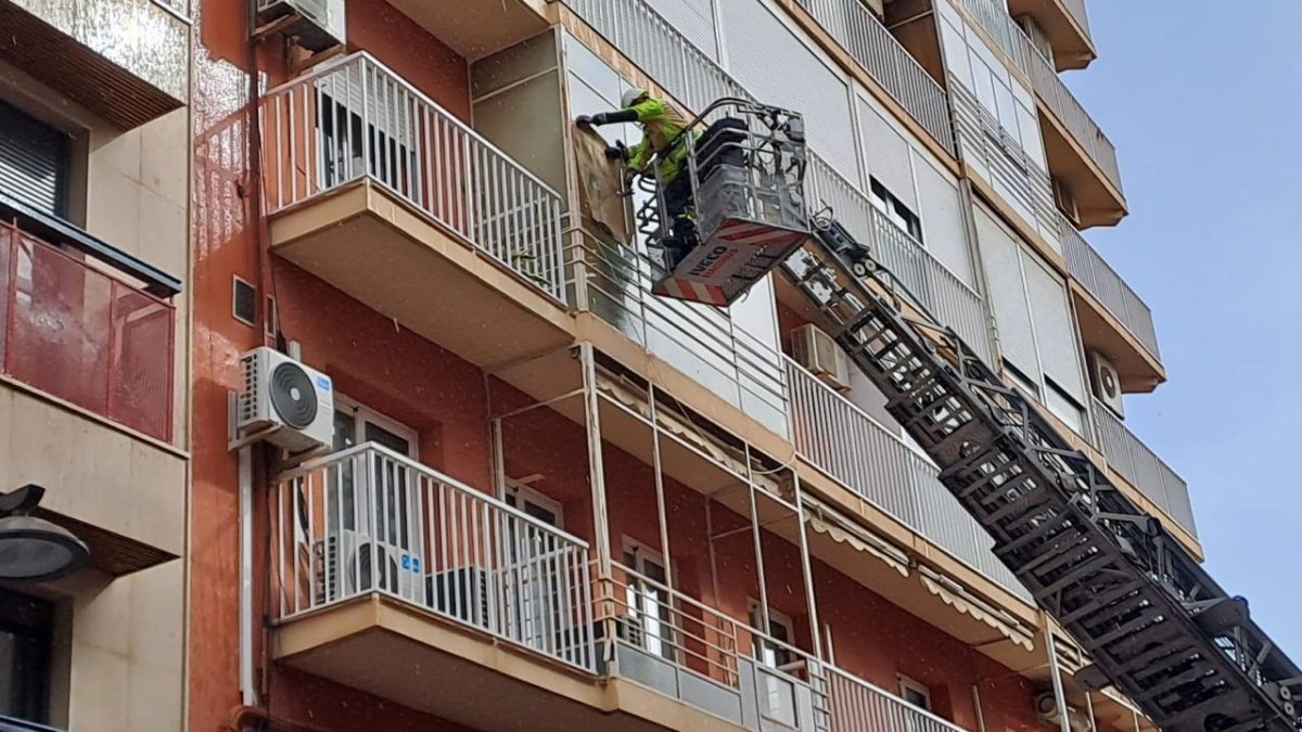 Los Bomberos de Almería trabajan en la ventana desde la que se han desprendido los cristales.