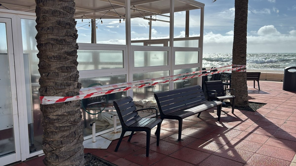 Precinto de la Policía Local junto a la terraza de un restaurante del Paseo Marítimo por la presencia de palmeras.