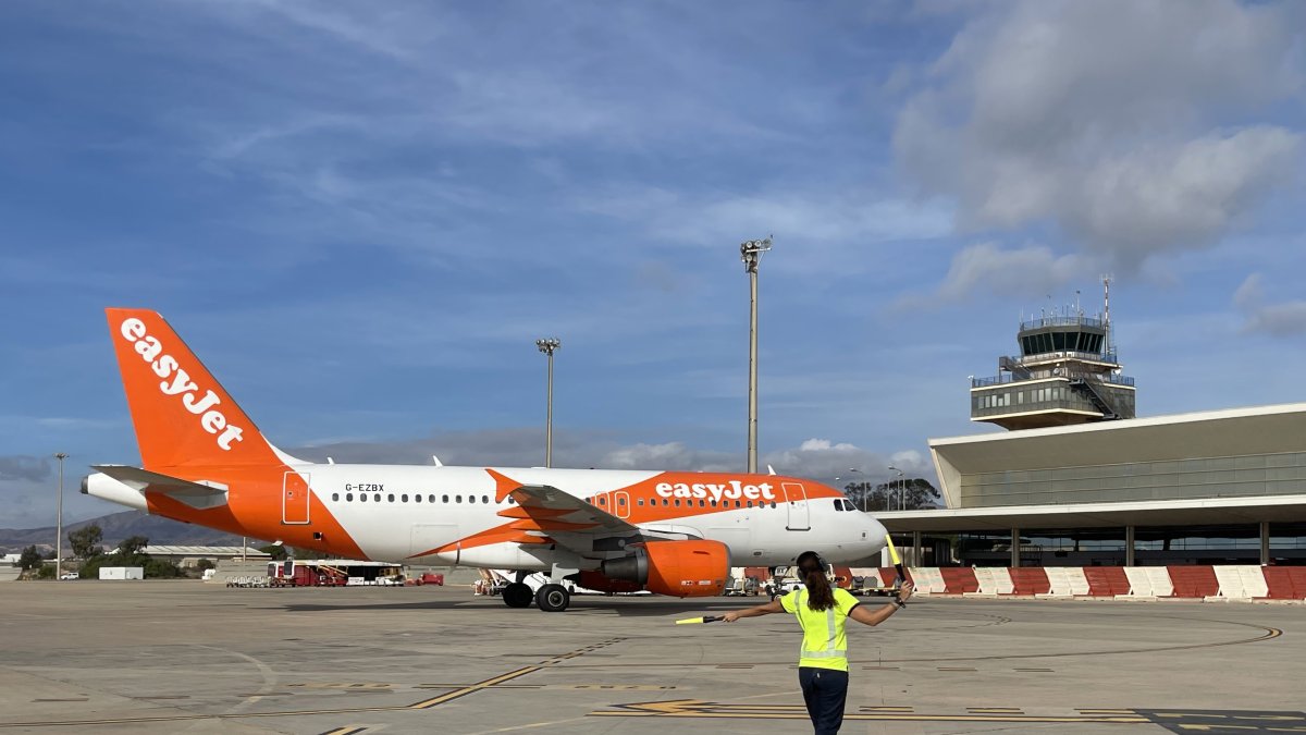 Archivo - Una operaria guía un avión en el Aeropuerto de Almería.