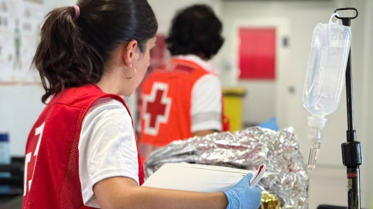 Miembros de Cruz Roja trasladan a inmigrantes al hospital tras ser localizados en el mar.