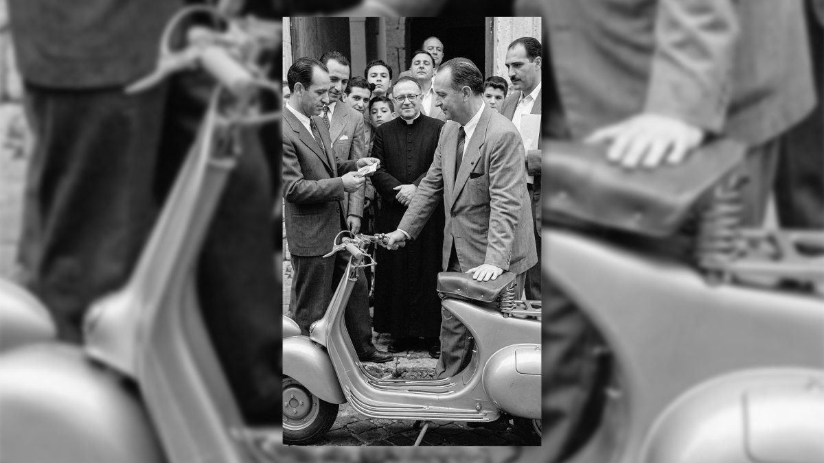 El juez municipal Mariano Fernández Ulibarri, recibiendo la Vespa que le había tocado en la tómbola ante el numeroso público congregado en la puerta del obispado. 1954.