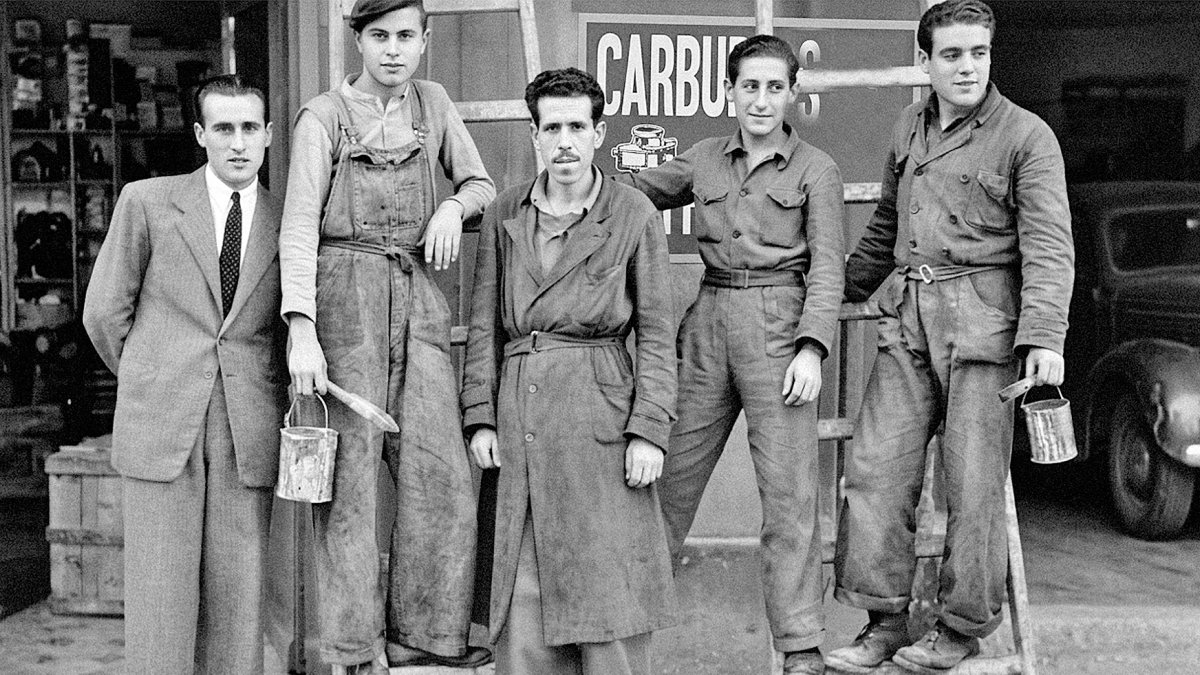 Empleados de la droguería El Triunfo, frente al kiosco de Amalia, en los años cuarenta. En la imagen aparecen dos pintores que estaban terminando un cartel en la fachada del negocio.