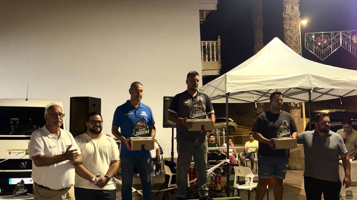 Podio de la general con los tres mejores clasificados recibiendo su trofeo
