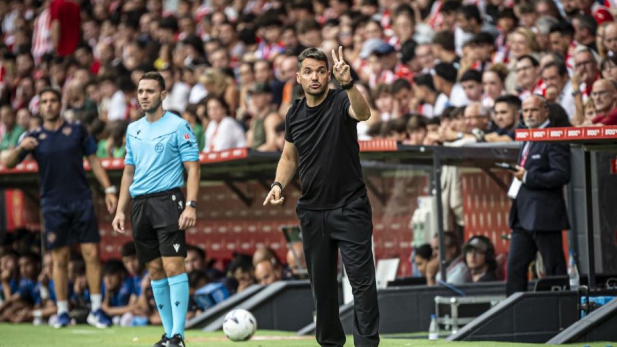 Ferran Costa dando instrucciones a sus jugadores en El Molinón.