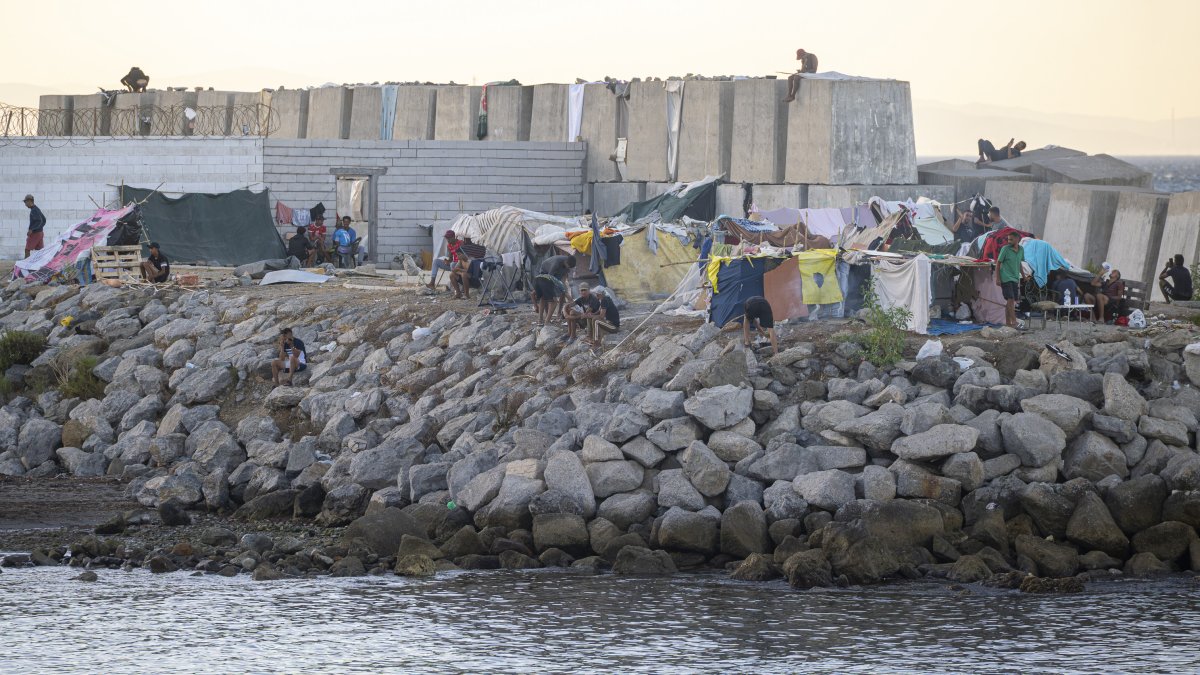Decenas de personas viven y pernoctan en la playa del Trampolín, a 28 de agosto de 2026, en Ceuta (España). En la zona de la playa del Trampolín permanecen aún cientos de migrantes en situación irregular, donde han vuelto a construir chozas.
