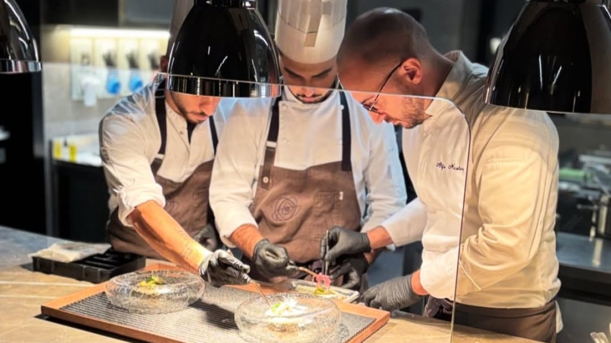 El chef Alfio Nicolosi, a la derecha de la imagen, durante la preparación de un plato.