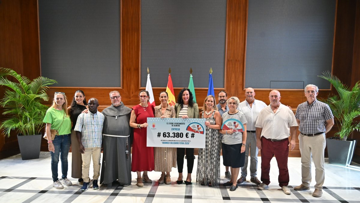 Foto de familia de la entrega de los cheques con el dinero recaudado en la venta de los abanicos de Feria.