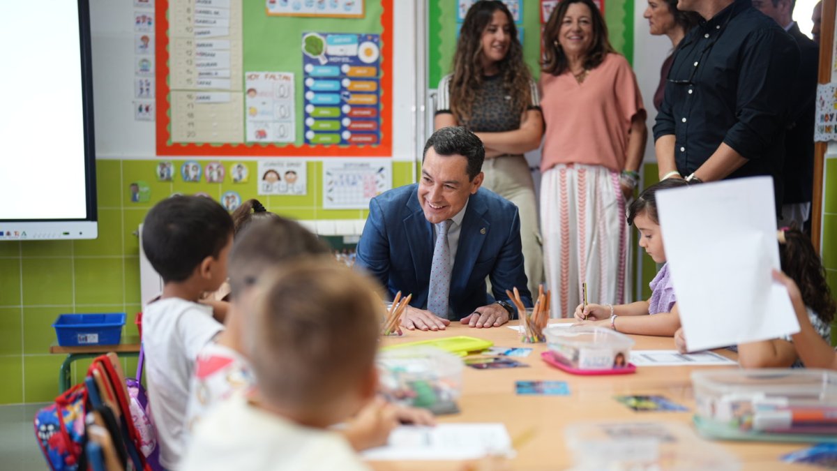 Juanma Moreno conversa con unos niños en el comienzo del curso escolar en Benahadux.