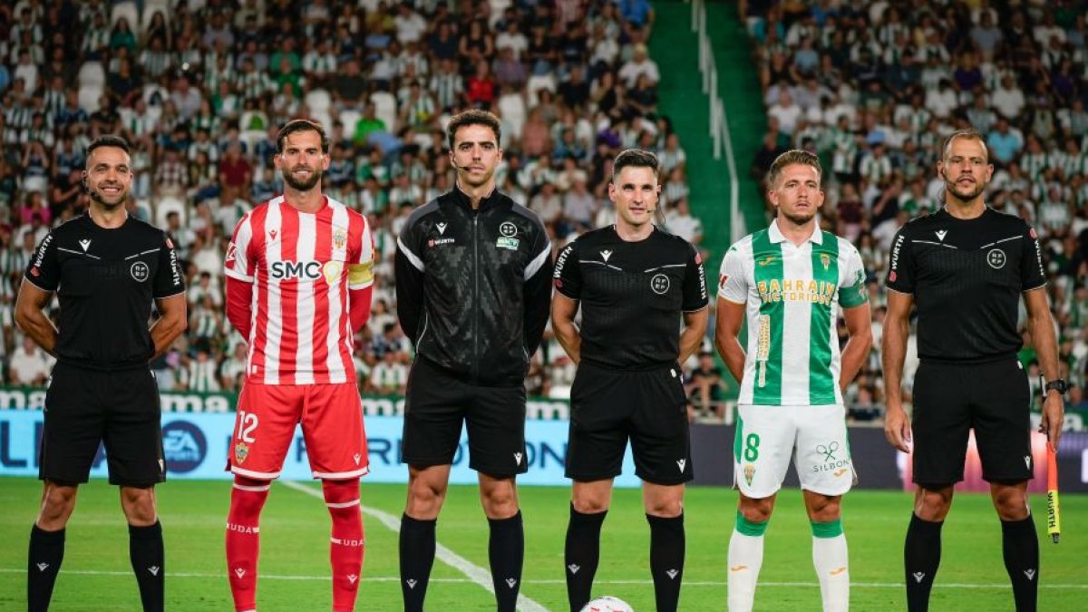 La foto de los capitanes y el equipo arbitral.