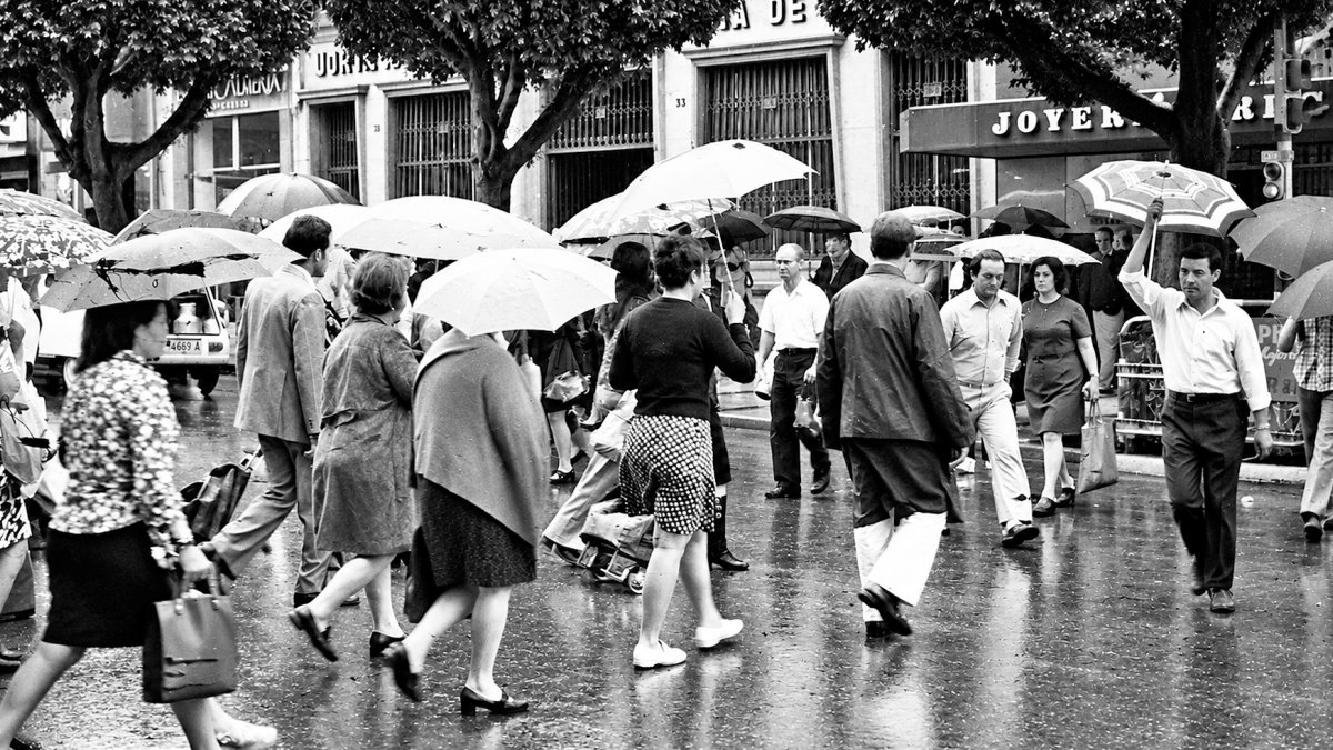 El otoño traía las primeras lluvias a Almería y la gente empezaba a sacar de los armarios la ropa de invierno. En la foto, un cruce del Paseo en un día lluvioso. Años 70.
