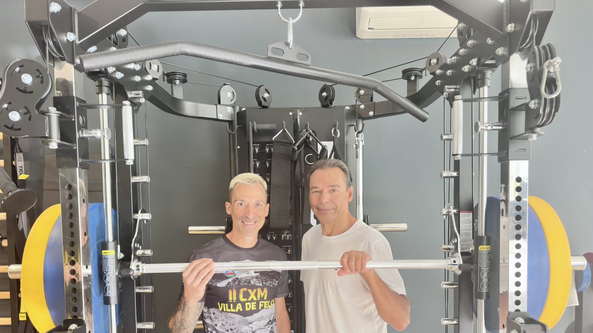 Ismael Blanco junto al periodista Antonio Hermosa, en uno de los aparatos de fuerza que tiene en su gimnasio
