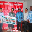 Brian Cipenga con los responsables de Kin Marché, recibiendo el cheque de 10.000 dólares americanos.