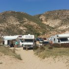 Decenas de coches y autocaravanas en el Playazo de Rodalquilar, algunas de ellas con toldos y mobiliario sacados.