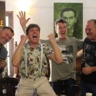 El periodista Salva R. Moya, con su libro, y tres de los miembros de la banda en la presentación de la biografía en El Pimpi de Málaga.