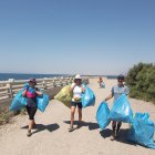 Algunos de los participantes con la basura recogida.