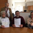 Los Payne sentados a la izquierda, mostrando la licencia de obras y la escritura.