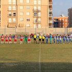 Los equipos se saludan en el centro del campo.