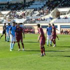Jugadores de ambos equipos aguardando un saque de esquina durante el partido.