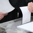 Un votante deposita su sobre en la urna