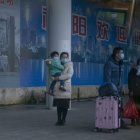 Una familia con una mascarilla en la estación de Nanning.