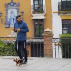 Un joven pasea a su perro en el barrio sevillano de Triana.