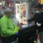 José Antonio Carreño con un cliente, en el supermercado que regenta en la calle La Reina