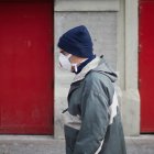 Una persona anda por la calle con mascarilla.