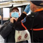 Un hombre recibe indicaciones sobre cómo colocarse la mascarilla, en la estación intermodal de Palma.