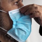 Un hombre se pone una mascarilla.