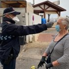 Un Policía Local le toma la temperatura a una mujer en la entrada del mercadillo de Garrucha