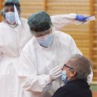 Una sanitaria toma muestras a una mujer.