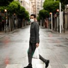 Un hombre con mascarilla recorre una vacía calle de Murcia.