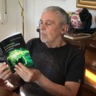 Pedro Blanco Naveros lee un ejemplar de su último libro sobre el universo.