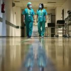 Dos sanitarios recorren el pasillo de un hospital.