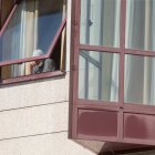 Un anciano de una residencia se asoma a través de la ventana.