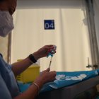 Una profesional sanitaria sostiene una jeringuilla y un vial con la vacuna contra la Covid-19.