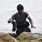Un migrante llega con sus zapatillas a la orilla.  /Antonio Sempere -Europa Press
