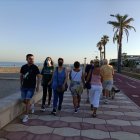 Varias personas disfrutando de una tarde de verano paseando frente al mar en Roquetas de Mar.