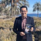 Alberto Cerezuela posa con un ejemplar de su segunda novela en el yacimiento de Turaniana.