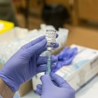 Una sanitaria sostiene un vial de la vacuna contra la COVID-19.