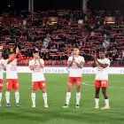 El equipo saludando y la afición con las bufandas al viento.