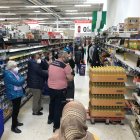 Un empleado de Carrefour repone aceite de girasol en las estanterías.