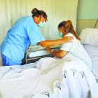 Una enfermera y una madre atienden a un bebé.