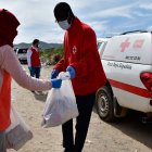 Un voluntario de Cruz Roja entrega productos de primera necesidad en un asentamiento de la provincia de Almería
