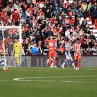 La Real celebrando y los jugadores del Almería hundidos.
