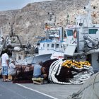 Marineros del Puerto de Almería arreglando las artes de traíña junto a una embarcación.